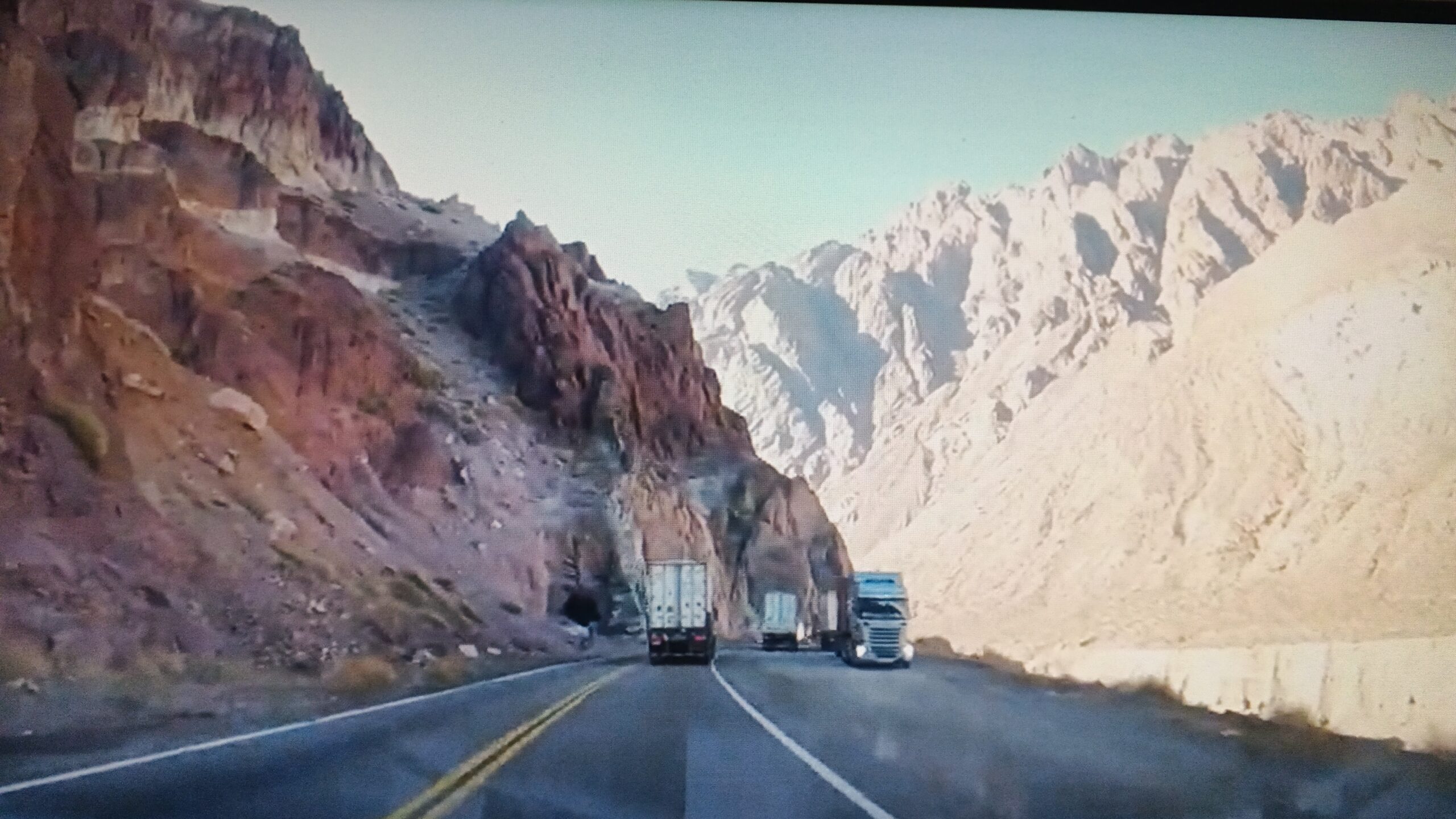 Camiones recorriendo la Cordillera de los Andes durante el Transfer Privado entre Mendoza y Santiago, Chile.